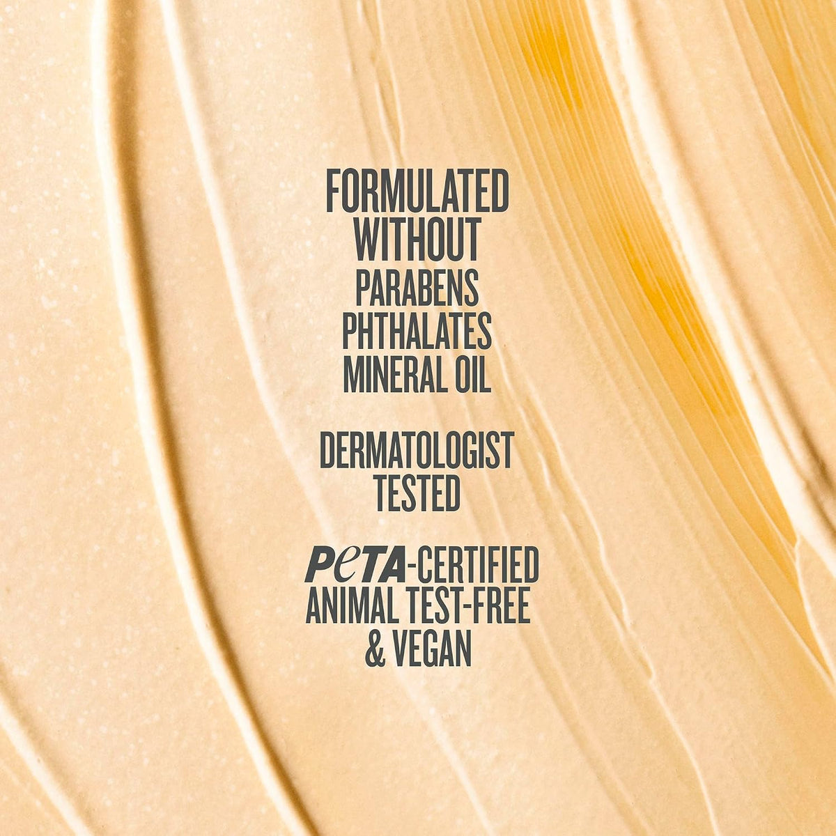 A close-up textured swatch of creamy beige cosmetic cream with dark gray text overlay reading 'FORMULATED WITHOUT PARABENS PHthalates MINERAL OIL DERMATOLOGIST TESTED PETA-CERTIFIED ANIMAL TEST-FREE & VEGAN'.