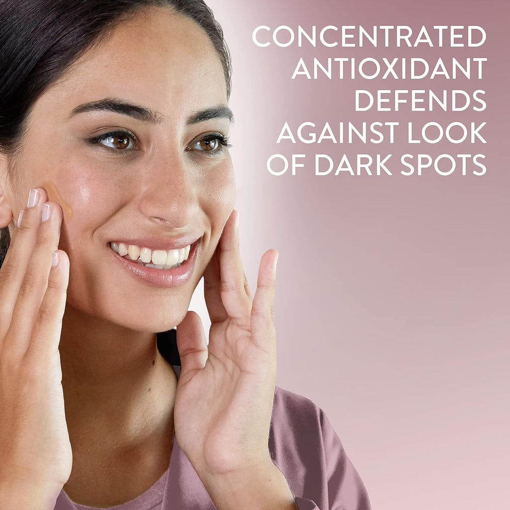 Woman touching her face with a pink background and text about antioxidant defense against dark spots.