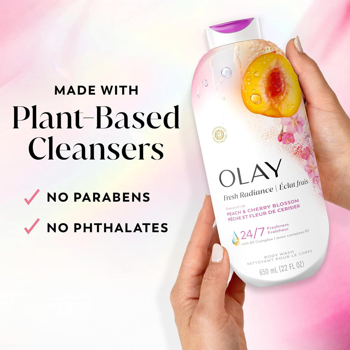 Olay body wash bottle held by a hand with product details on a colorful background
