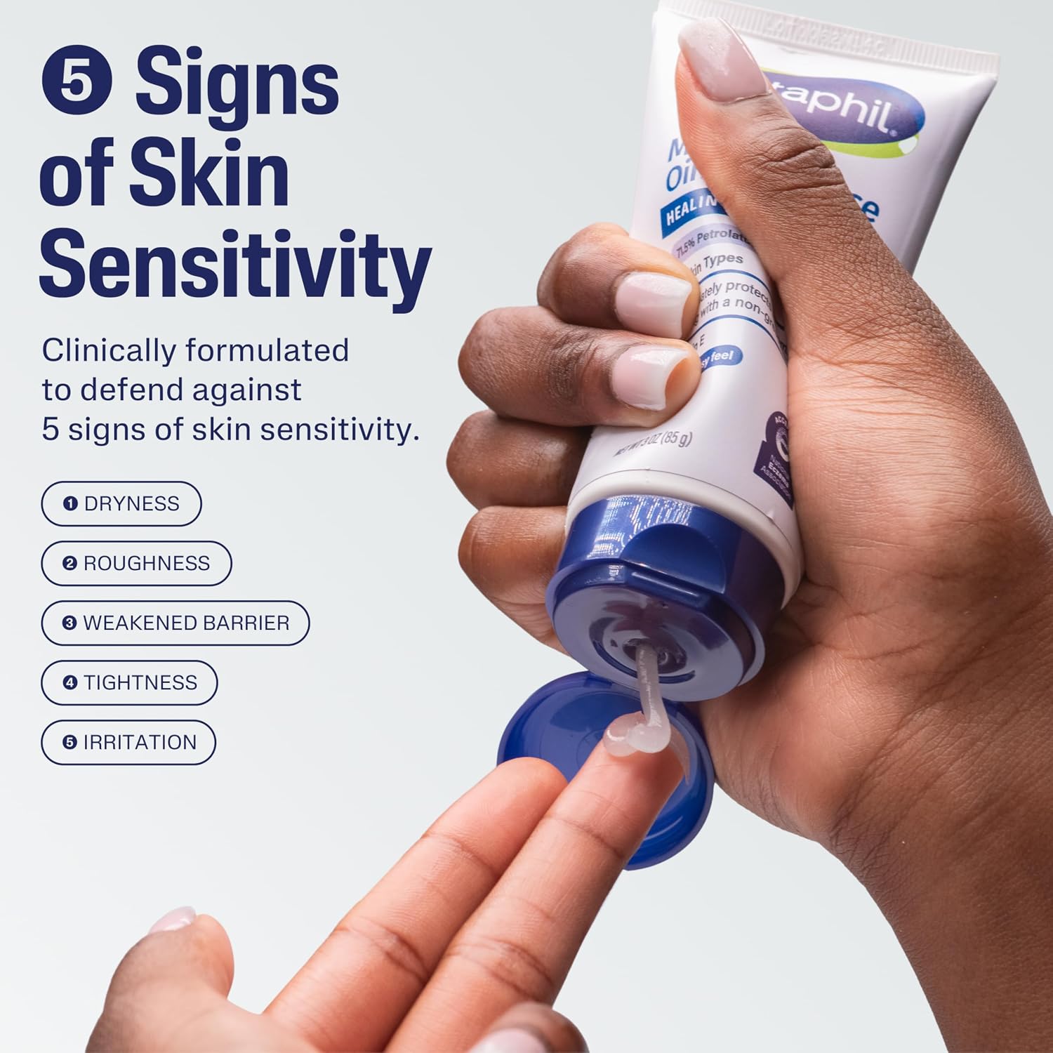 Hand applying a tube of Zephil cream with text about skin sensitivity signs on a light gray background