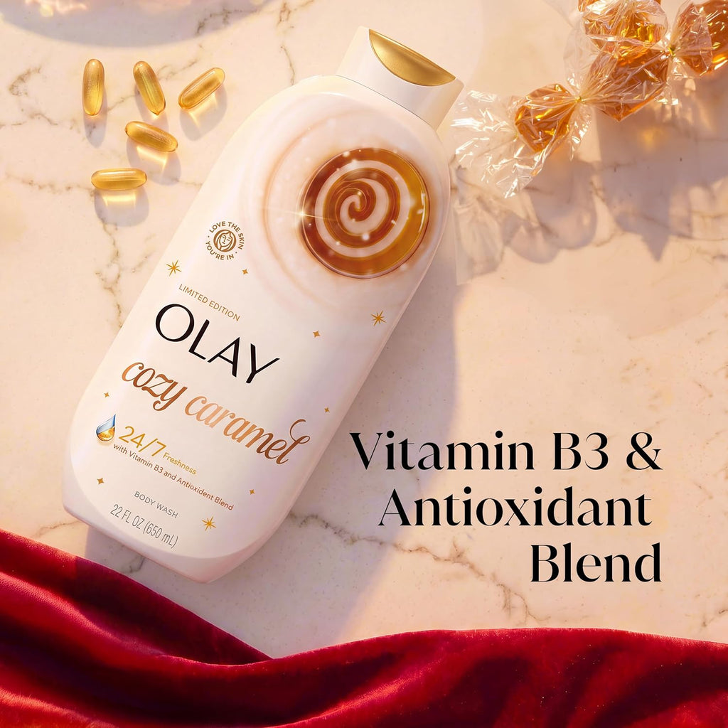 Olay Cozy Caramel body wash bottle on a marble surface with gold capsules, wrapped caramel candies, and a red velvet cloth. Text overlay reads 'Vitamin B3 & Antioxidant Blend'.