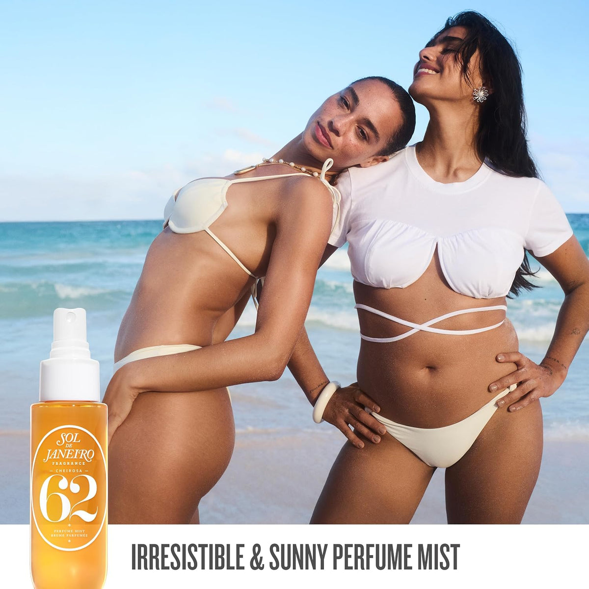 Two women in swimsuits on a beach with a bottle of Sol de Janeiro perfume mist.