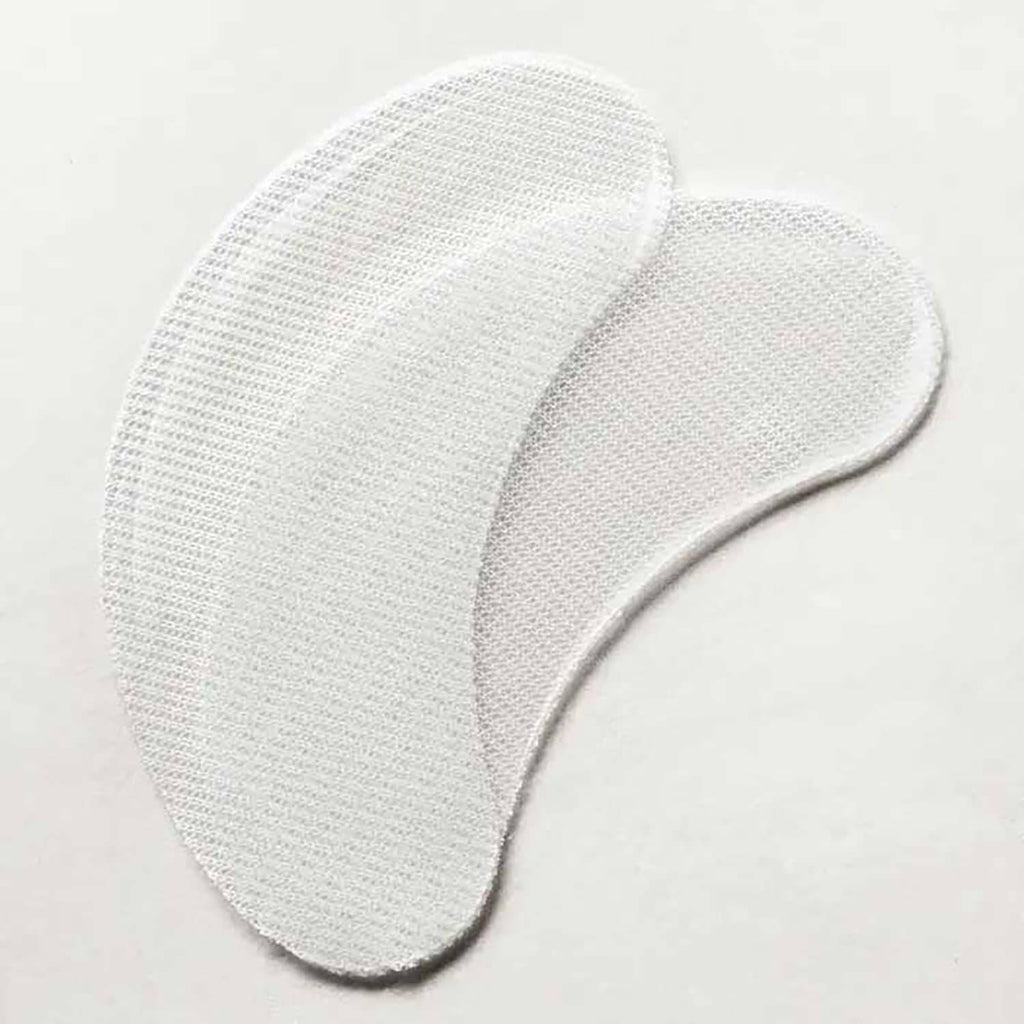 Two white mesh eye patch pads with stitched edges, arranged overlapping on a plain light background.
