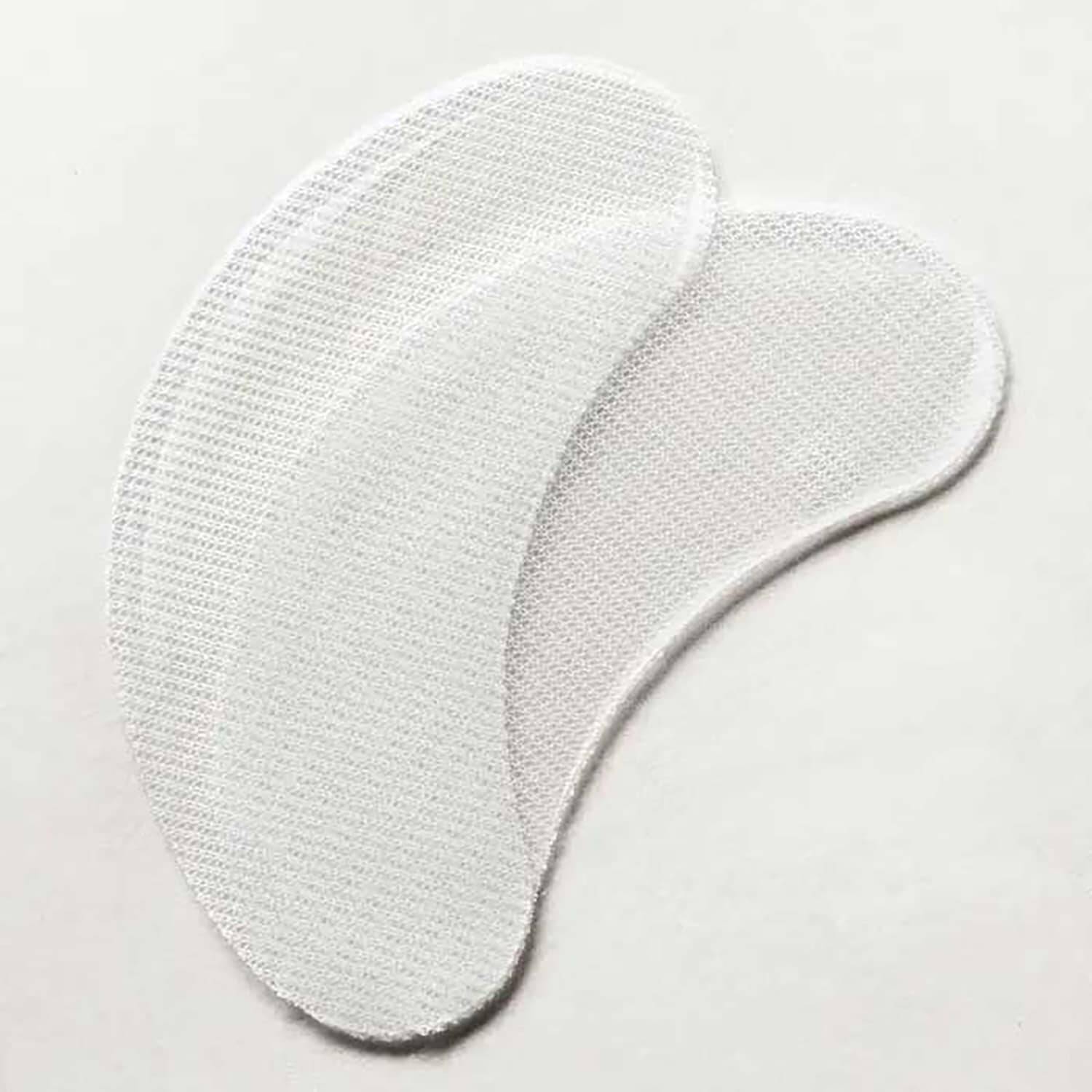 Two white mesh eye patch pads with stitched edges, arranged overlapping on a plain light background.