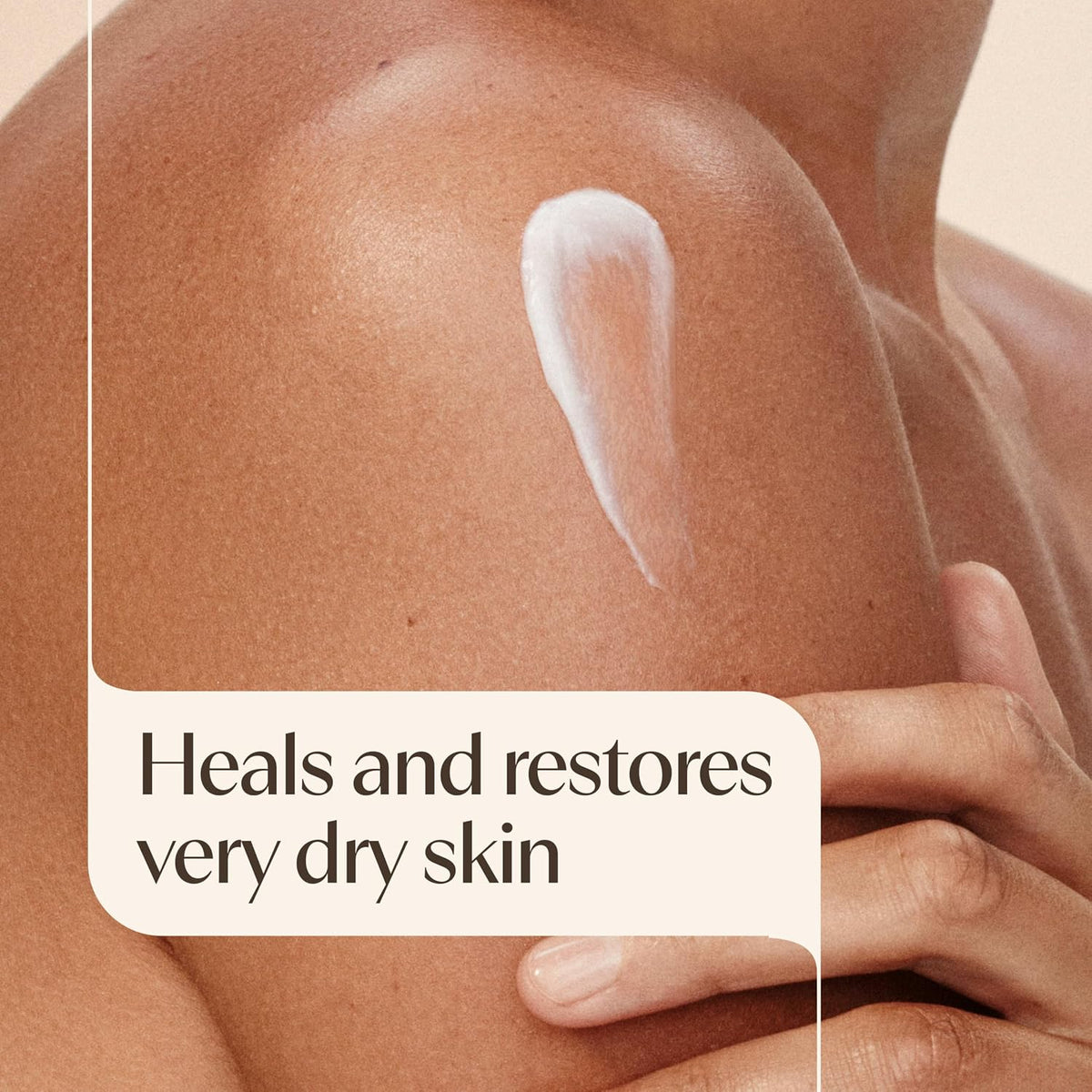 Close-up of a person's shoulder with a white cream swatch applied, alongside text that reads 'Heals and restores very dry skin'.
