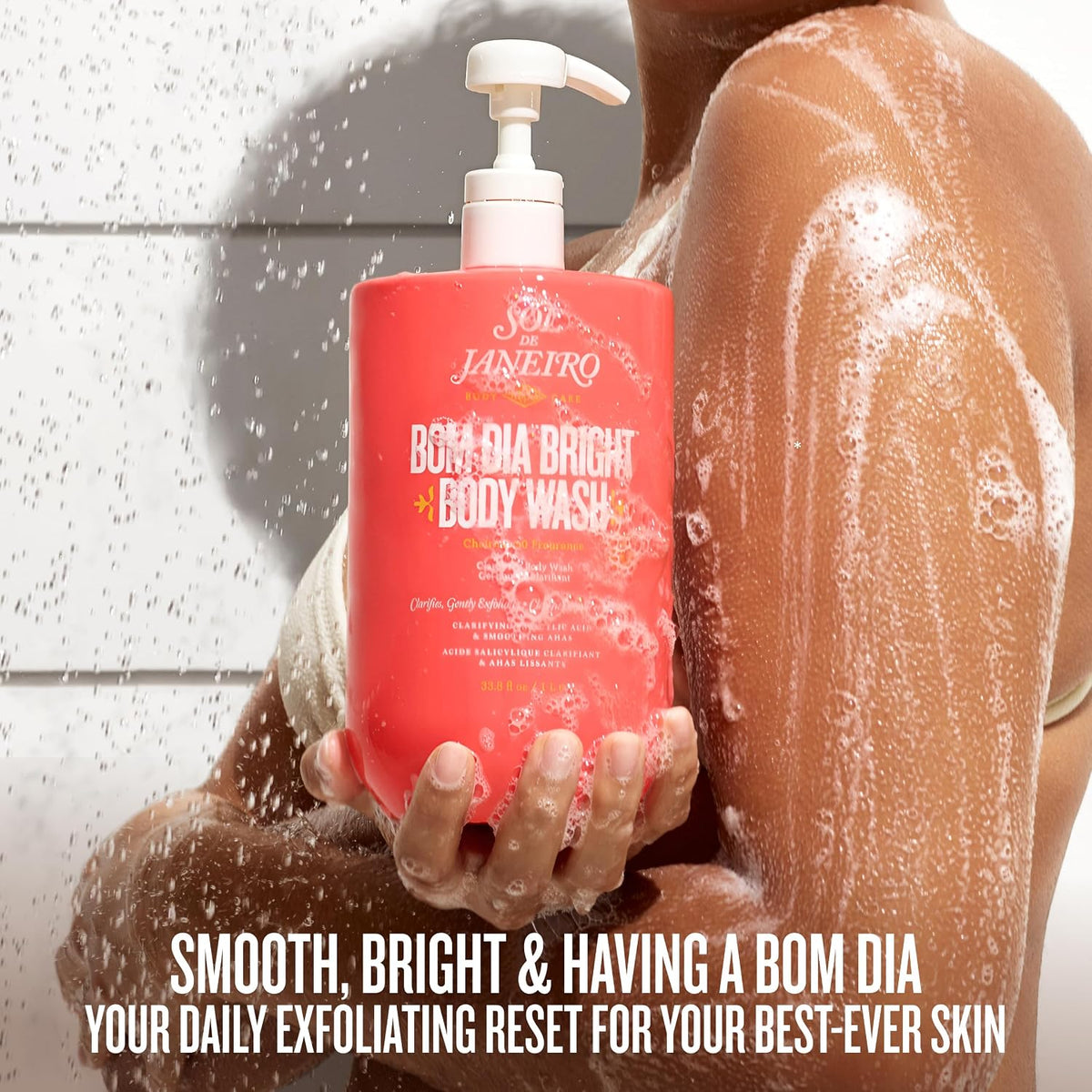 Person holding a bottle of Bom Dia Bright body wash with a shower in the background
