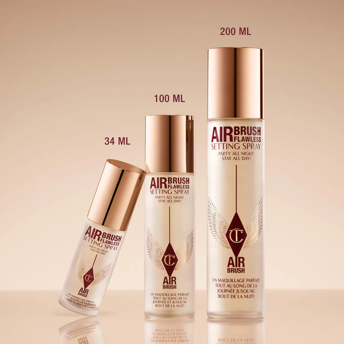 Three bottles of Airbrush Flawless setting spray on a beige background