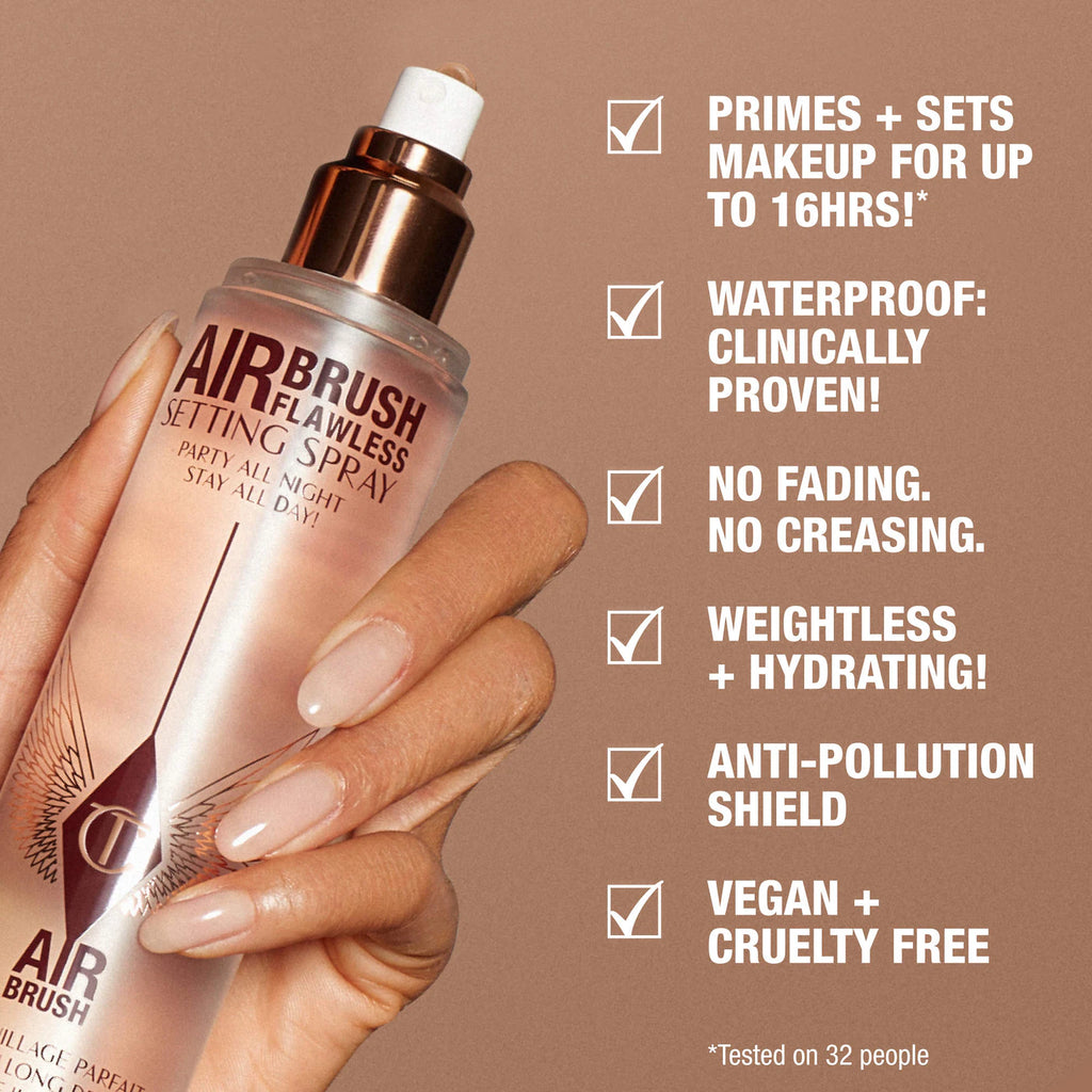 Hand holding Airbrush Flawless Setting Spray with product features listed on a brown background