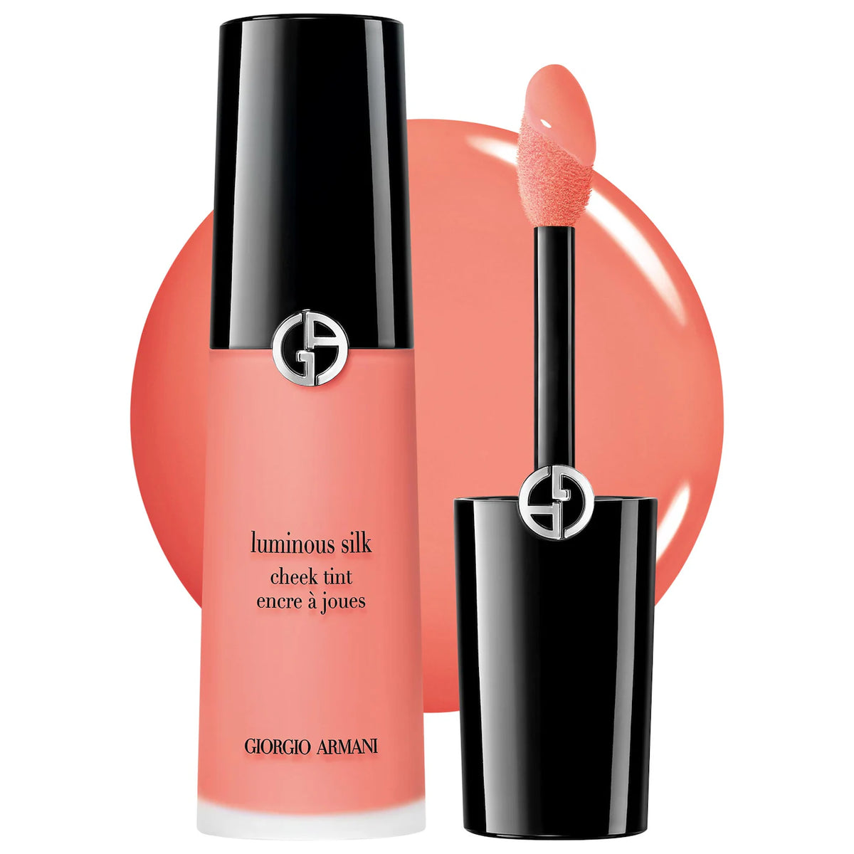 Giorgio Armani Luminous Silk Cheek Tint in a coral pink shade, showing the bottle, cap, and applicator wand against a white background with a matching coral circular backdrop.