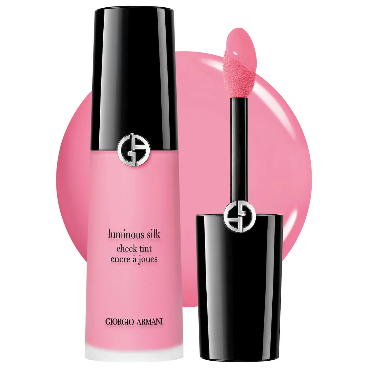 Giorgio Armani Luminous Silk Cheek Tint in a pink shade, showing the black and frosted pink bottle alongside the applicator wand with a pink-tinted sponge tip, set against a pink circular swatch on a white background.
