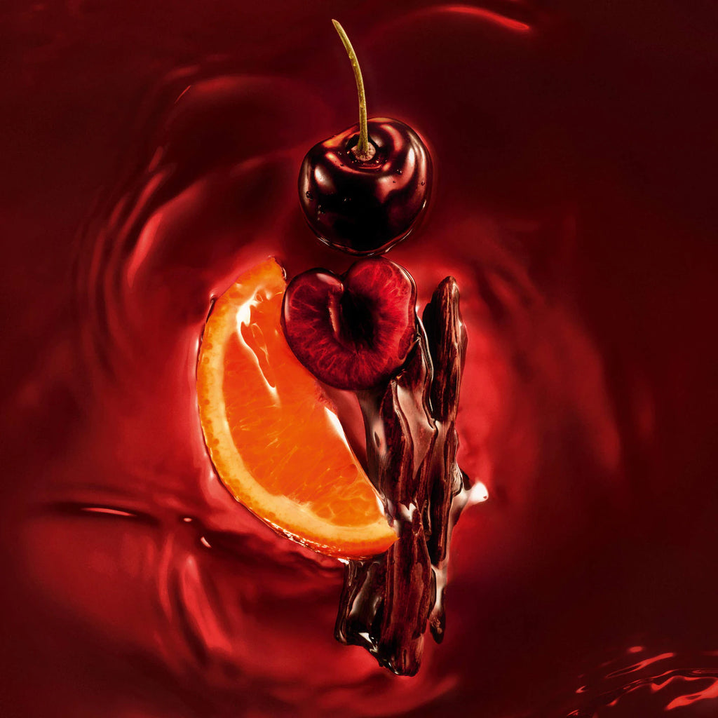 Cherry and orange slice with chocolate sauce on a red background