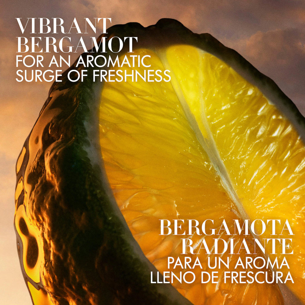 Aromatic fragrance artwork featuring a close-up of a bergamot half with bold white text reading 'Vibrant Bergamot For An Aromatic Surge Of Freshness' and 'Bergamota Radiante Para Un Aroma Lleno de Frescura' over a warm orange sky background.