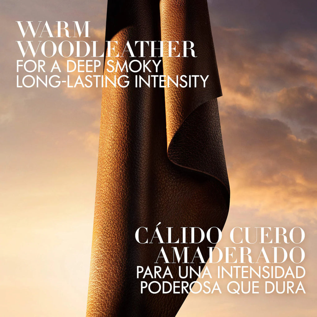 A rolled sheet of warm brown wood-look leather shown against a dramatic sunset sky, with large white text overlay in English and Spanish describing the scent profile.
